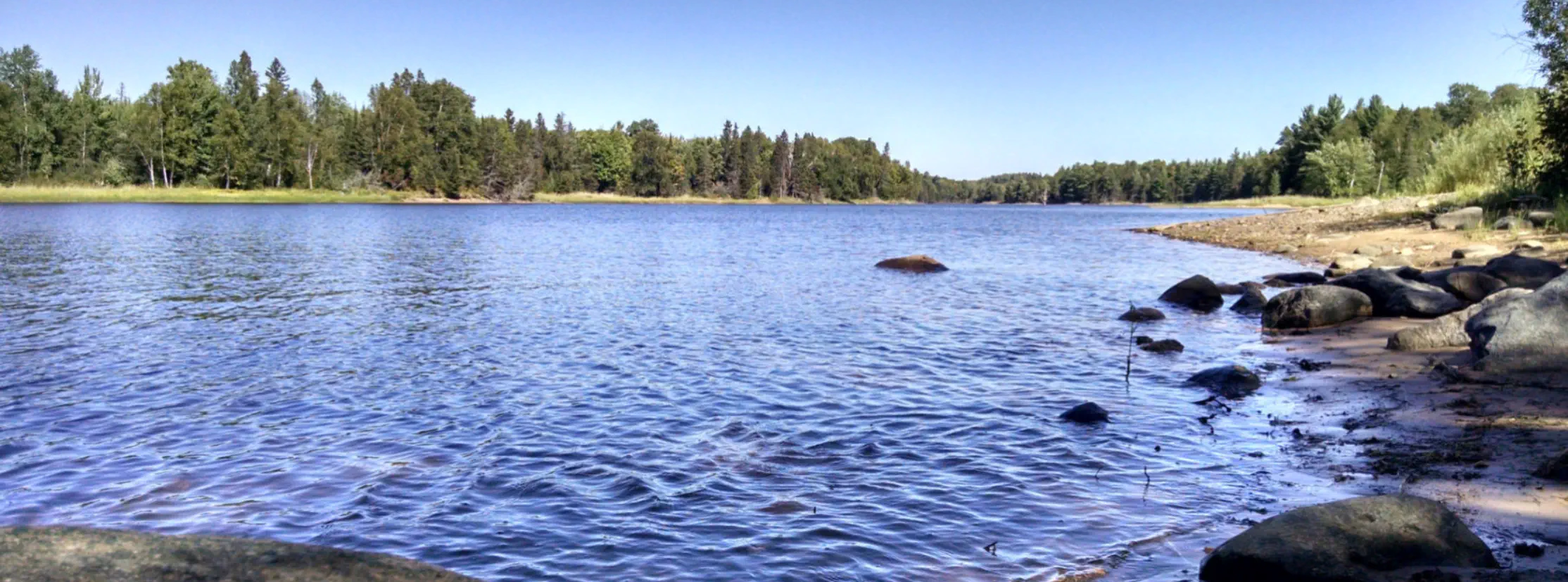 Lake with rocky beach in Sagola Township